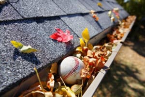 Gutter full of autumn leaves with baseball