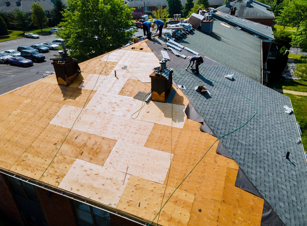 Roof repair replacing an old roof with new shingles of an apartment building