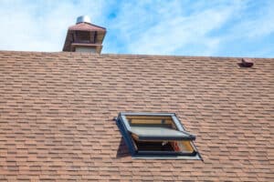 New roof with skylight, asphalt shingles and chimney