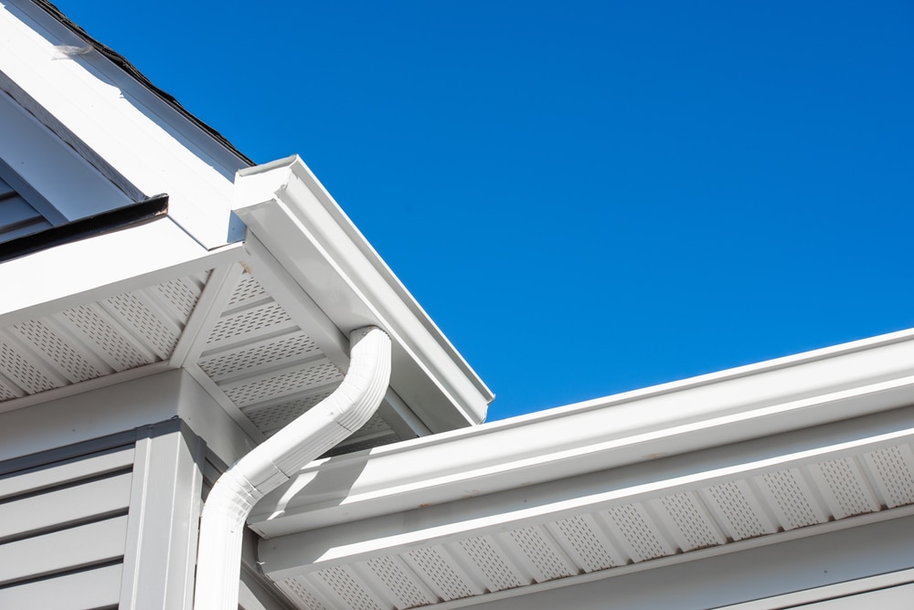 Colonial white gutter system ceiling providing attic ventilation for home with shingle roof