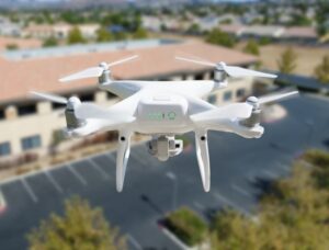 Unmanned aircraft system quadcopter drone in the air near a corporate industrial building