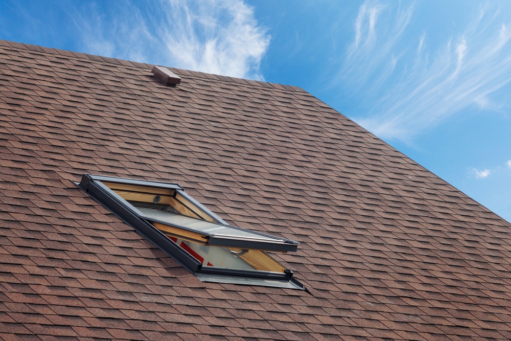 Roof with a skylight and asphalt shingles