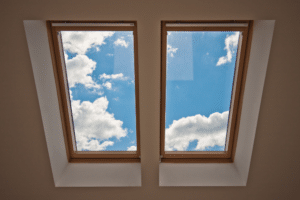 Sunlit sky viewed through attic window in the house with skylights