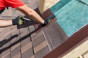 Builder-roofer marks the distance between the seams on a shingle roof