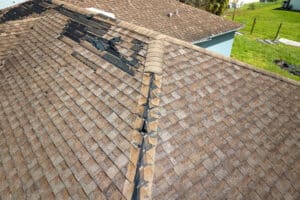 Damaged house roof with missing shingles