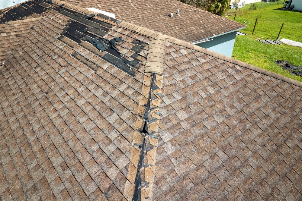 Damaged house roof with missing shingles