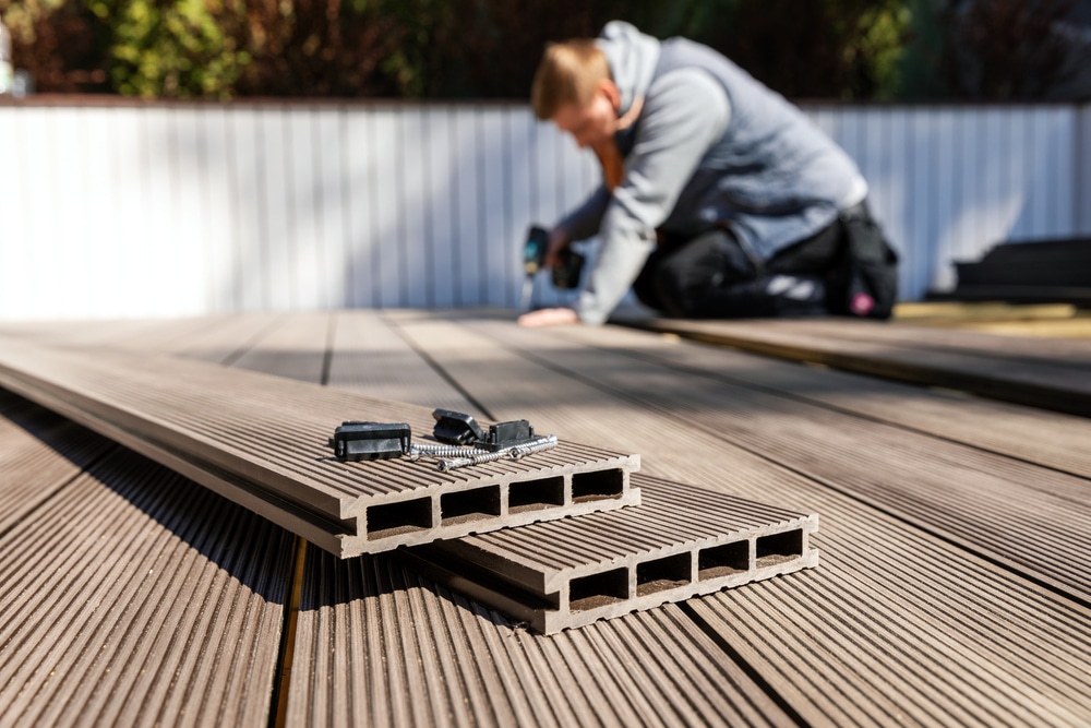 A worker installs wood-plastic composite decking boards