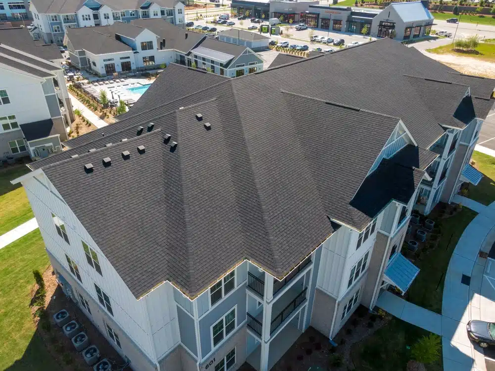 Drone images of new apartments with asphalt shingle roofs.
