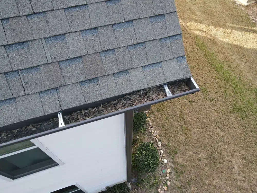 Clogged rain gutters on a two story roof.
