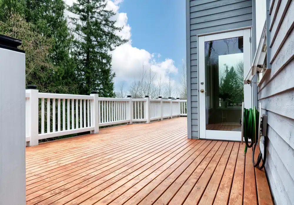 Wood deck patio with trees and sky in background