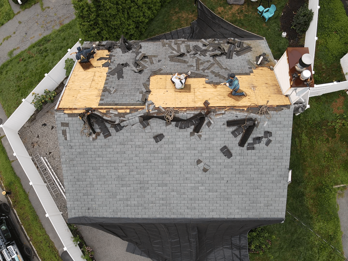 Team of roofers collaborating on a replacement project