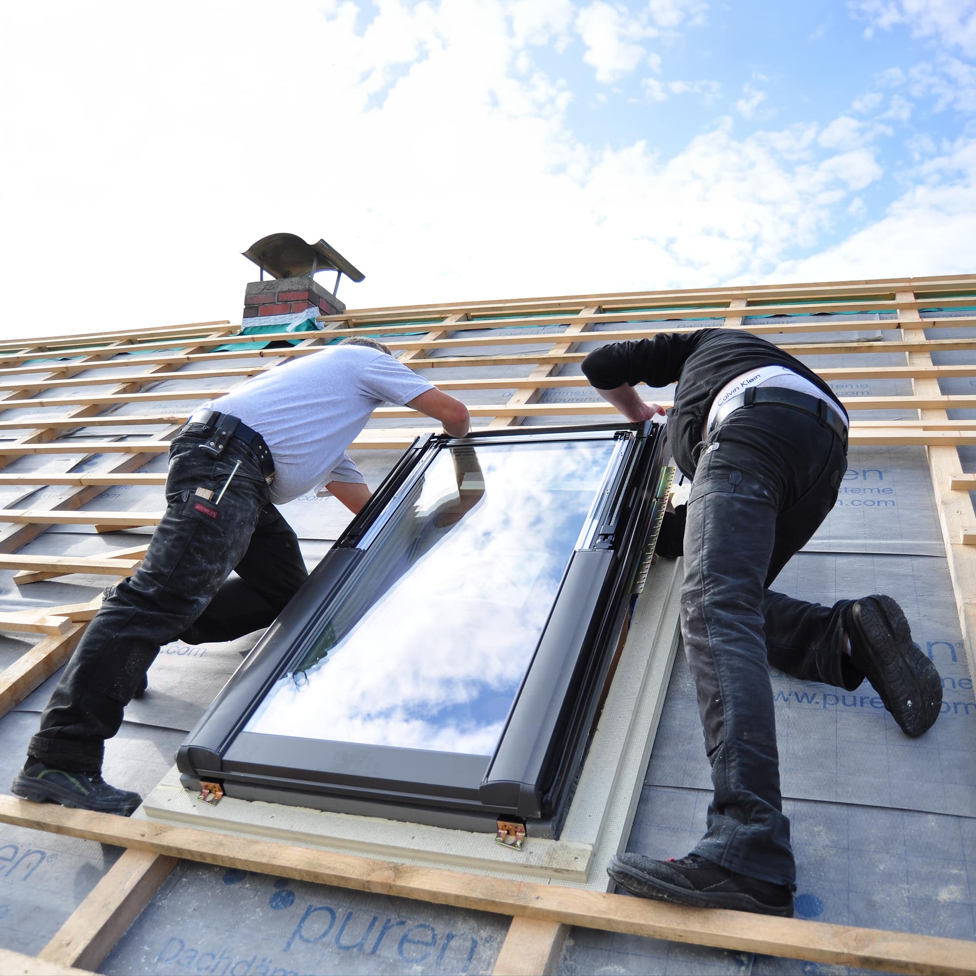 Skylight installers working on a rooftop
