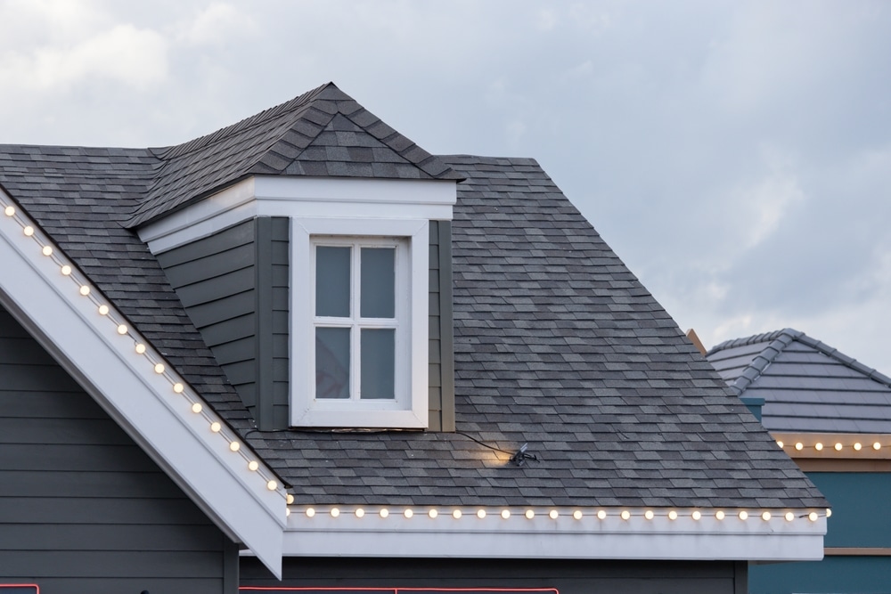  A house with shingle roof and a window on the top