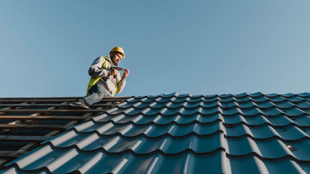 Repairer working on metal roofing