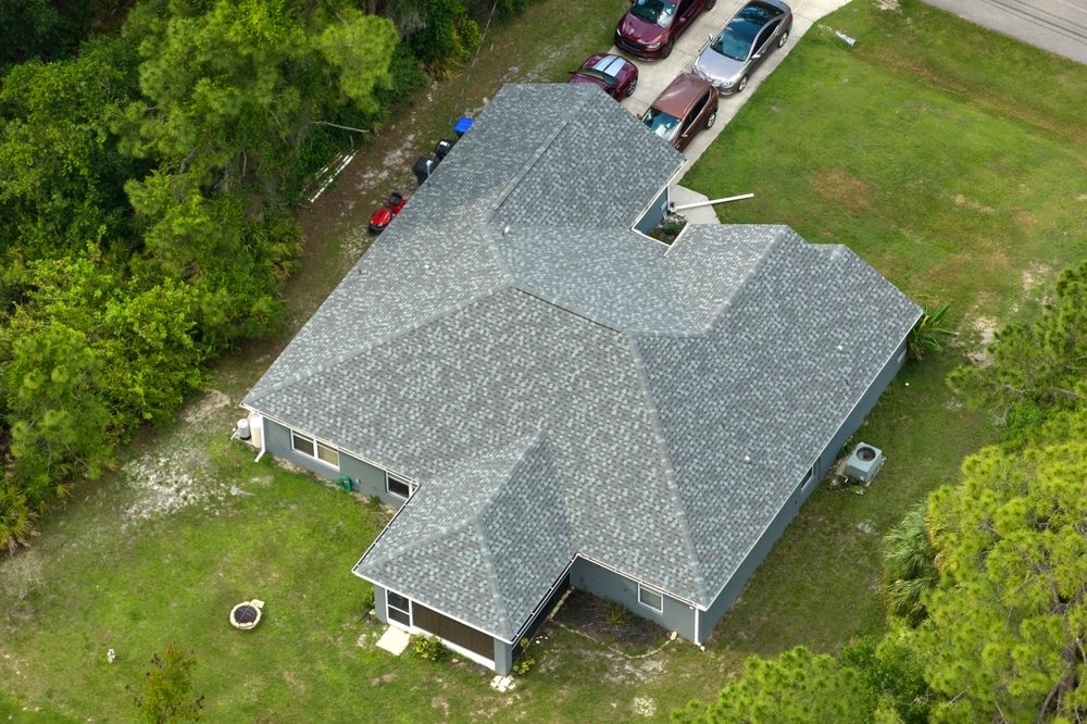 Aerial view of typical contemporary american private house with roof top covered with asphalt shingles.
