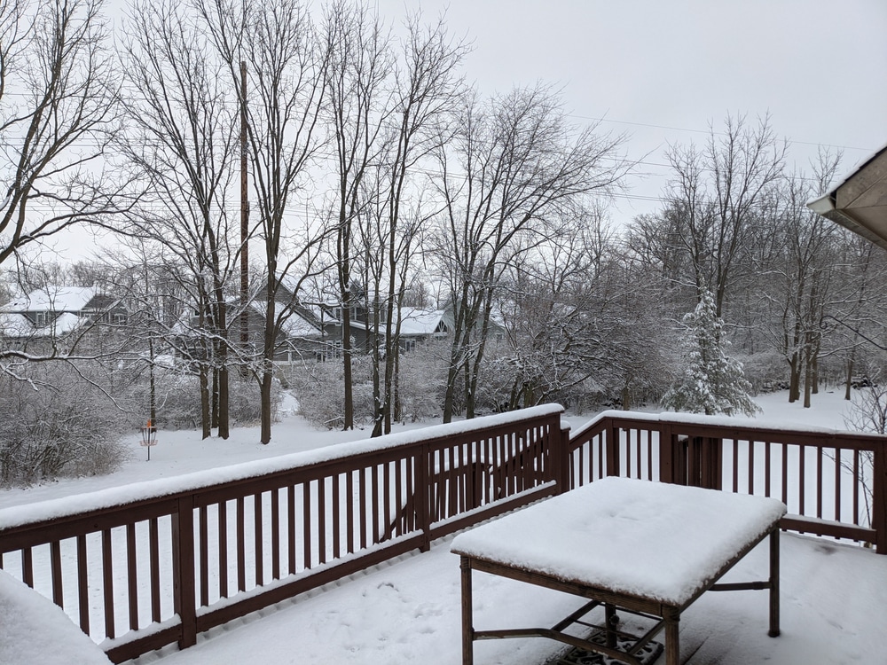 Clouds sky pond cat tails, winter season snowfal on the deck ground and outdoor deck furniture