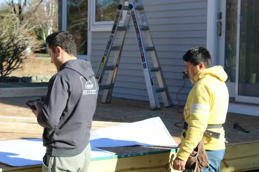 CAN Roof Construction team working on roof installation, two male roofing contractors in working clothes