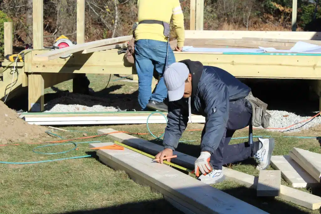 CAN Roof Construction team working on roof installation, two male roofing contractors in working clothes