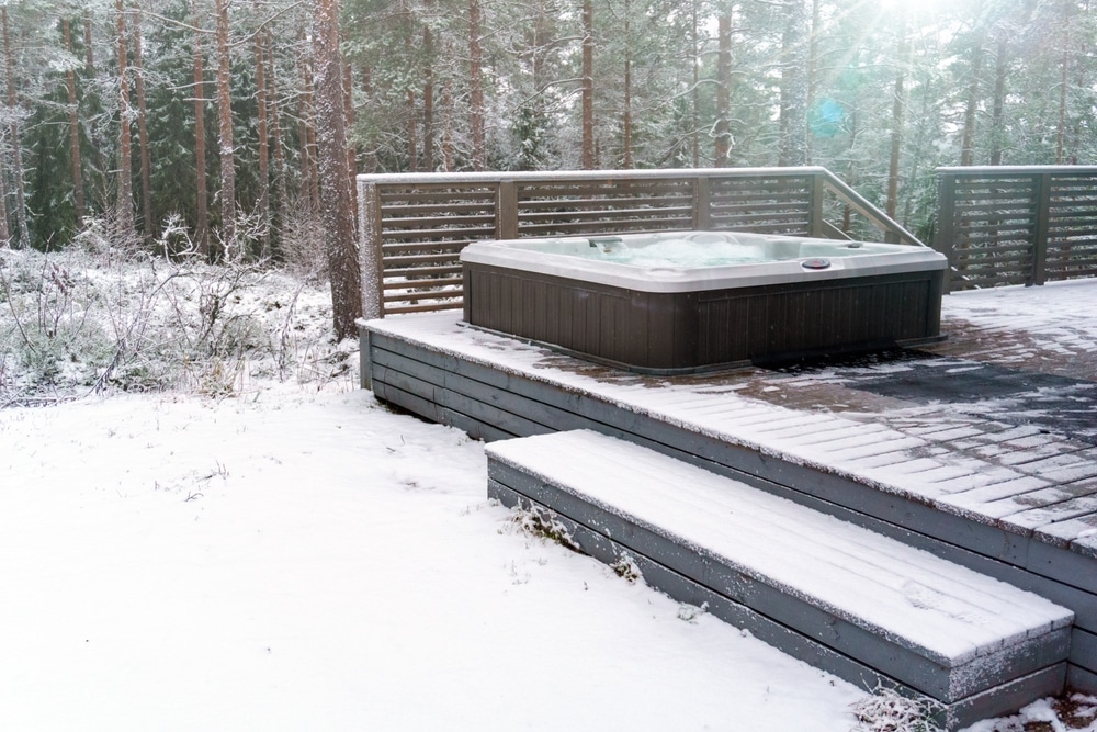 Modern outdoor hot tub on a wooden deck in the cold winter day, outdoor space in winter with deck, deck maintenance