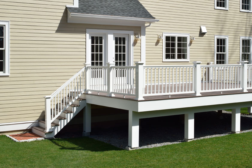 Custom-built deck with white railings and stairs, enhancing outdoor living space with expert deck building in Boston