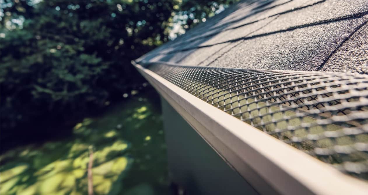 Gutter system with protective mesh for debris prevention and water drainage, ensuring reliable gutter services in Boston MA