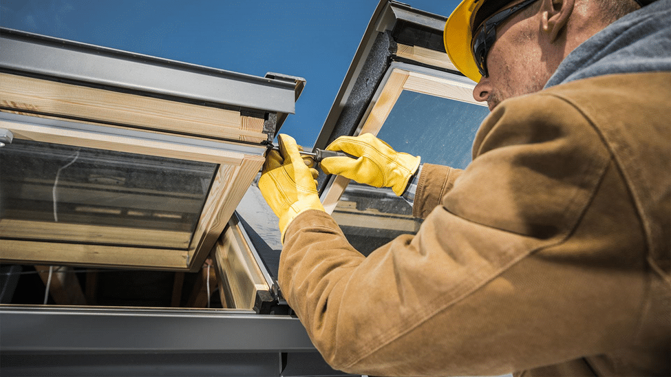 A contractor installing a skylight on a flat roof skylight, ensuring proper insulation, waterproofing, and energy efficiency