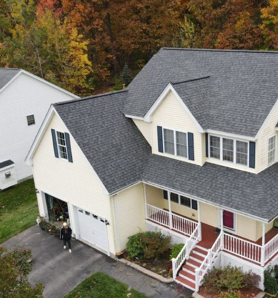 A house with a completed roof installation in Boston, featuring dark gray asphalt shingles and a well-maintained exterior