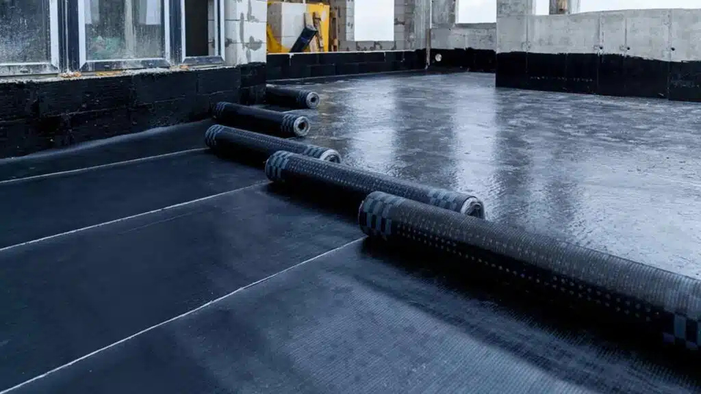 Installation of a bituminous waterproofing membrane on a flat roof, ensuring durable weather protection.