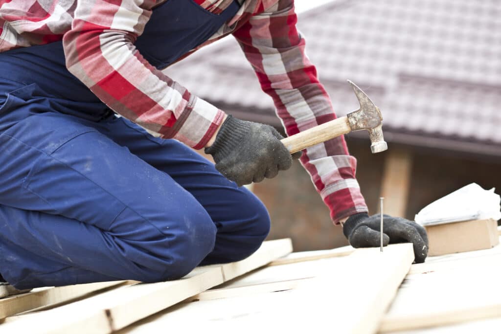 Old roof being replaced with new roofing materials on a house