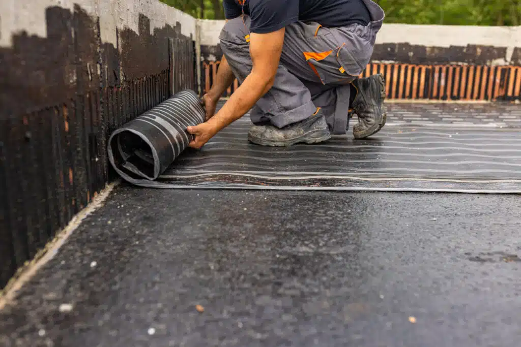 Roof underlayment being rolled out over decking during roof installation