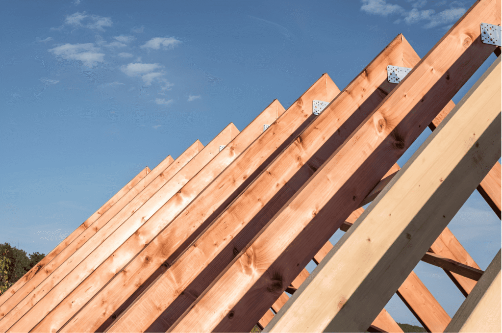 New roofing construction showing wooden roof trusses prepared for professional roof installation