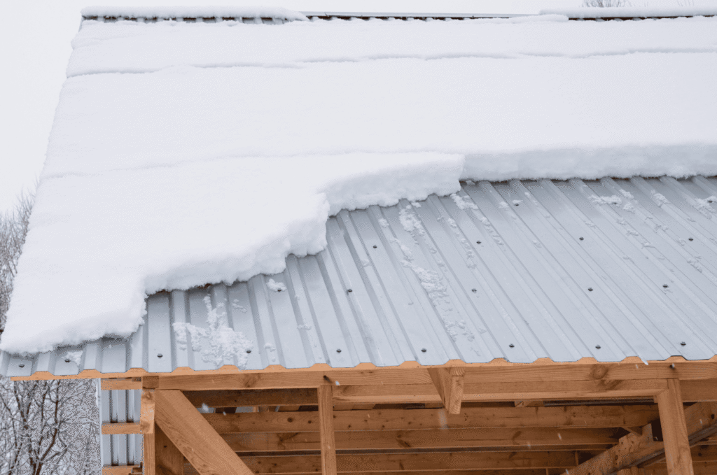 Metal roof holding heavy snow loads, demonstrating roof preparation for winter and structural readiness