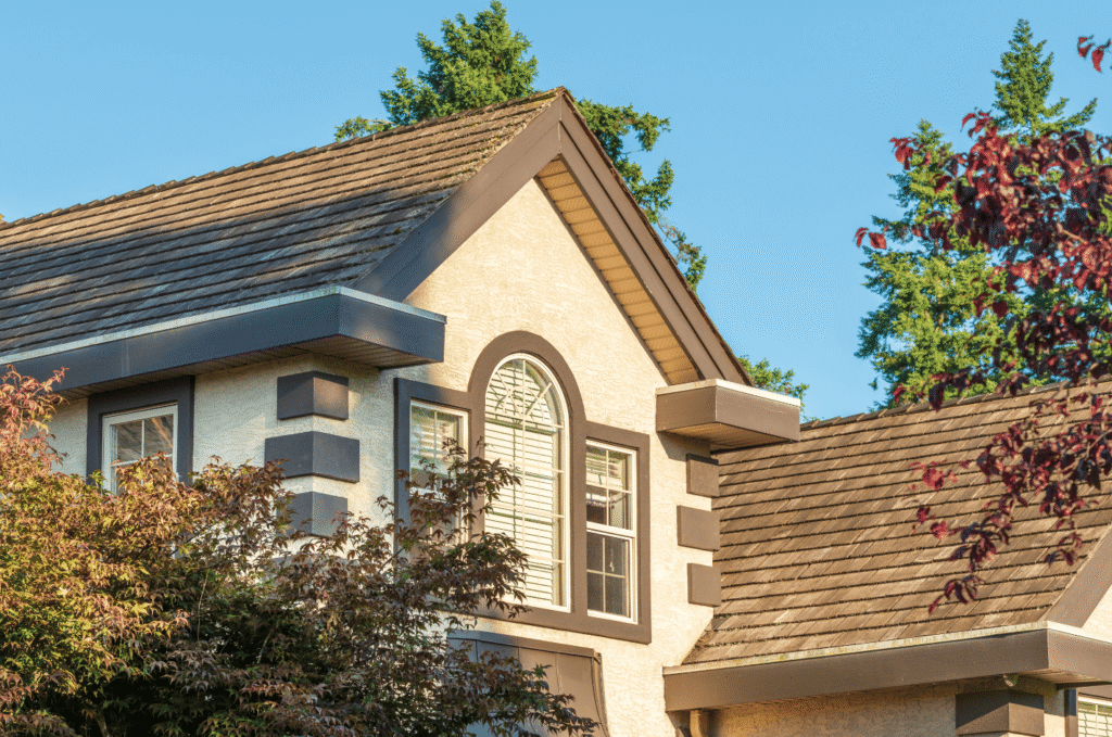 Well-maintained home roof surrounded by trees, showing the quality work many roofing companies provide for residential homes