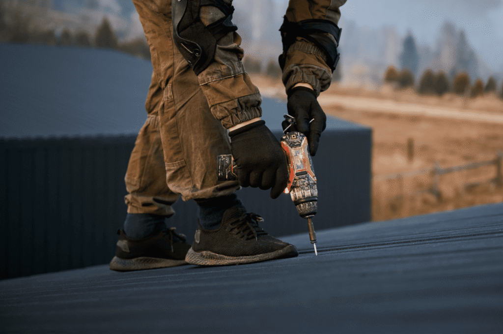 Roofing constructors using power tools to secure roofing materials, ensuring strong and reliable roof installation