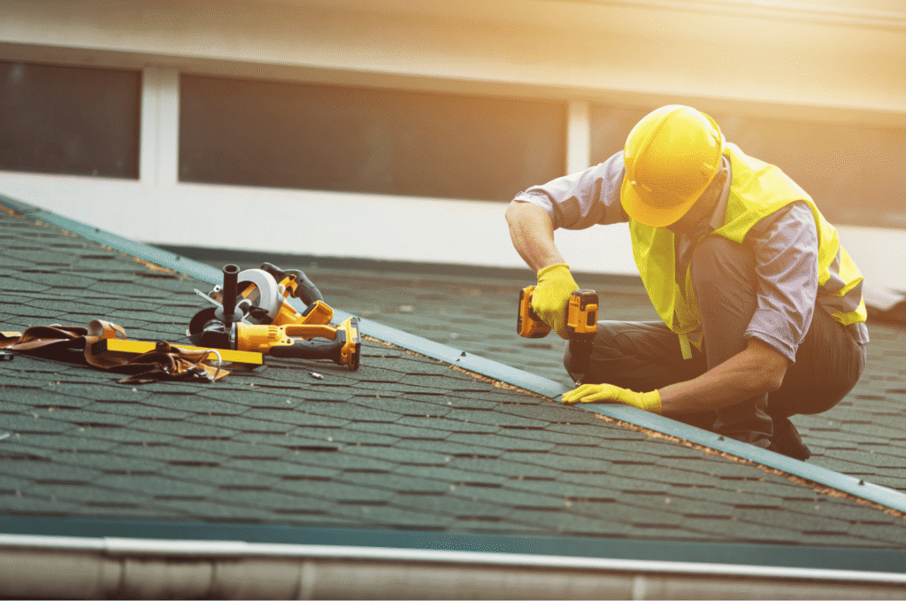 Worker using tools during roof repair to fasten roof materials and strengthen the roof against weather damage