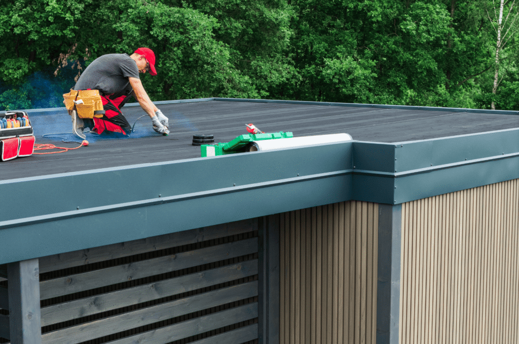Technician sealing seams on an EPDM roof, maintaining a flat roof system that helps prevent leaks and extends roof lifespan