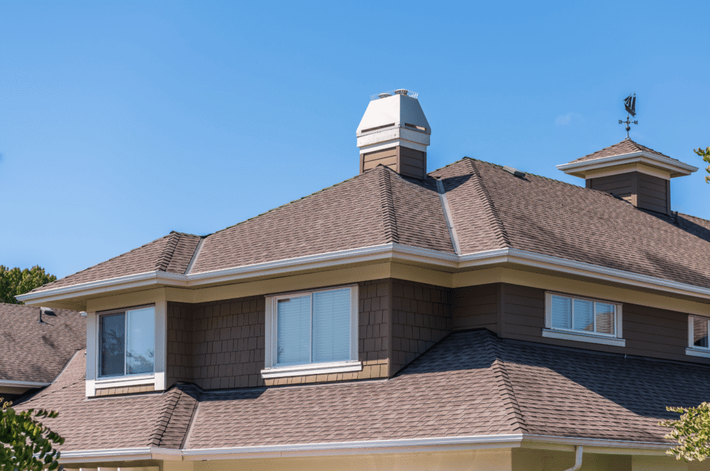 Large residential home roof viewed during a roof inspection to check shingles, vents, and roof structure for damage