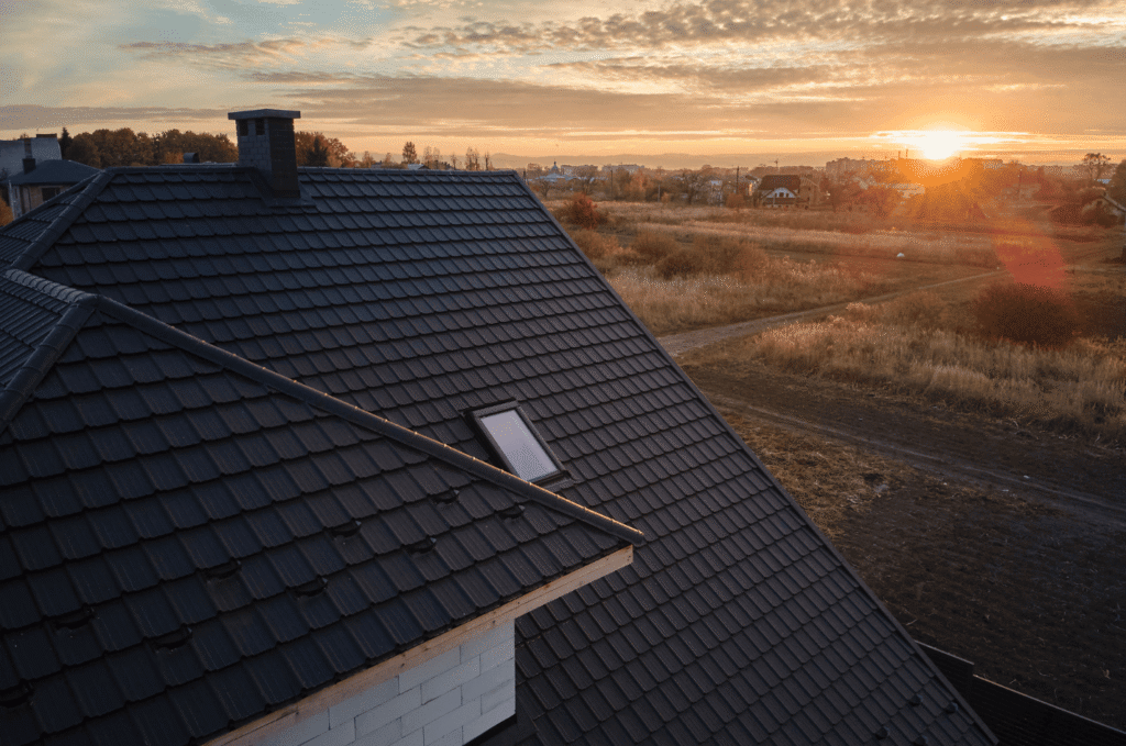 Dark tile roof with skylight viewed during roof maintenance to check for loose tiles and maintain proper water drainage