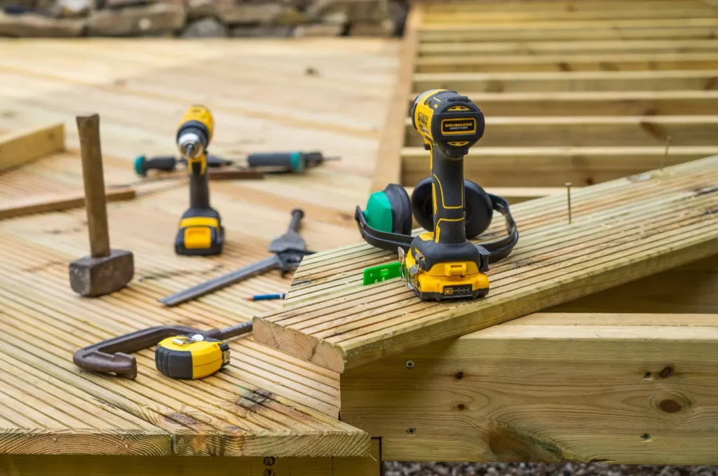 Tools and wood boards placed on a new frame during deck building, showing early steps of deck repair and installation