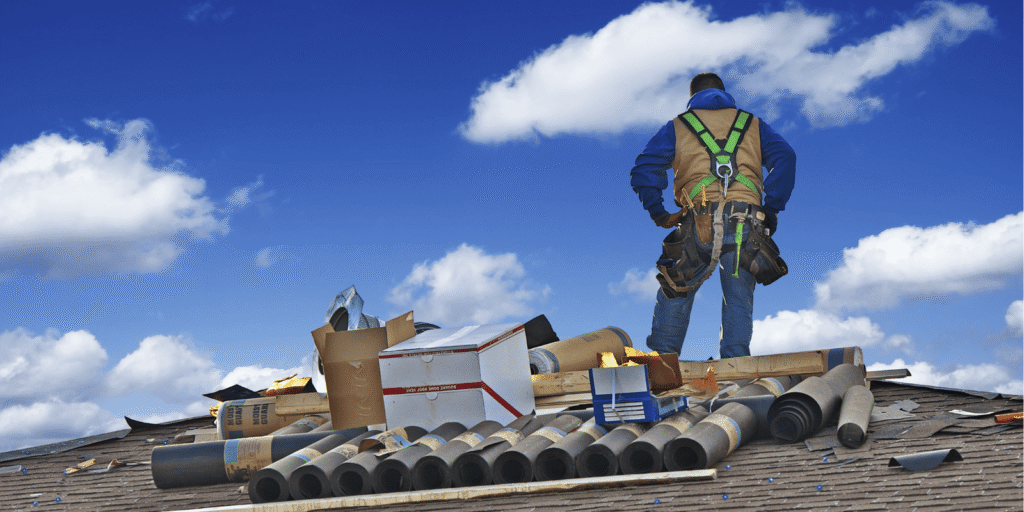 Roof installation service in progress with underlayment rolls and roofing materials prepared on a residential rooftop