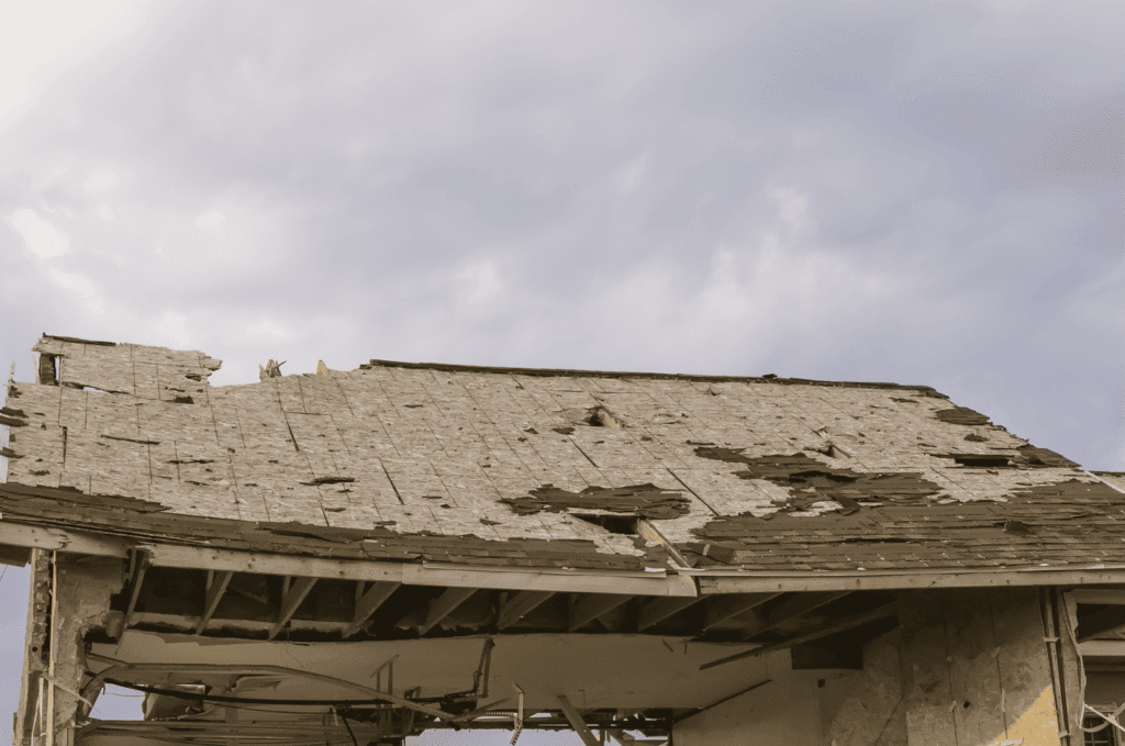 Roof damage caused by UV exposure and environmental wear showing brittle aging shingles with visible granule loss over time