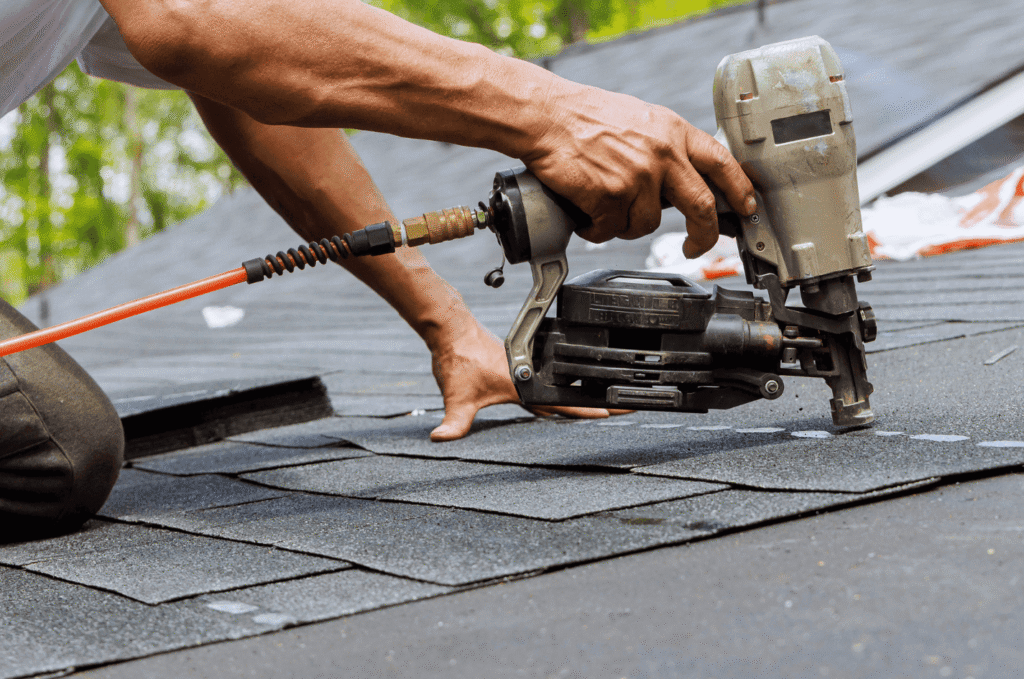 Roofer installing asphalt shingles during roof patch repair to help prevent leaks, moisture damage, and costly repairs