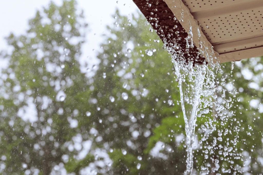 Rainwater overflowing from roof gutter, showing roof drainage problems that can lead to home water damage