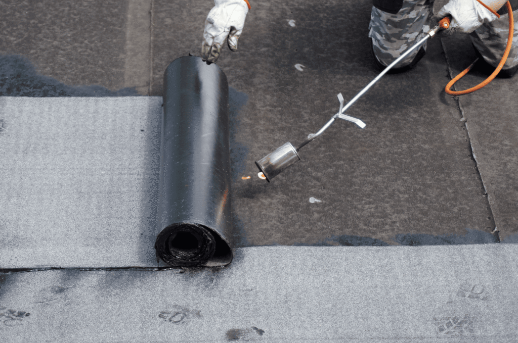 Torch-applied flat roof membrane showing installation conditions that may lead to blistering if moisture gets trapped below 