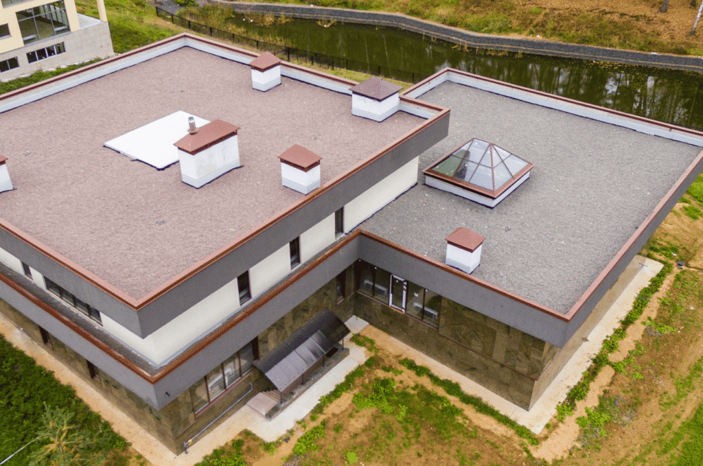 Aerial view of commercial flat roof sections, showing areas to monitor for ponding water, leaks, and roof maintenance needs.