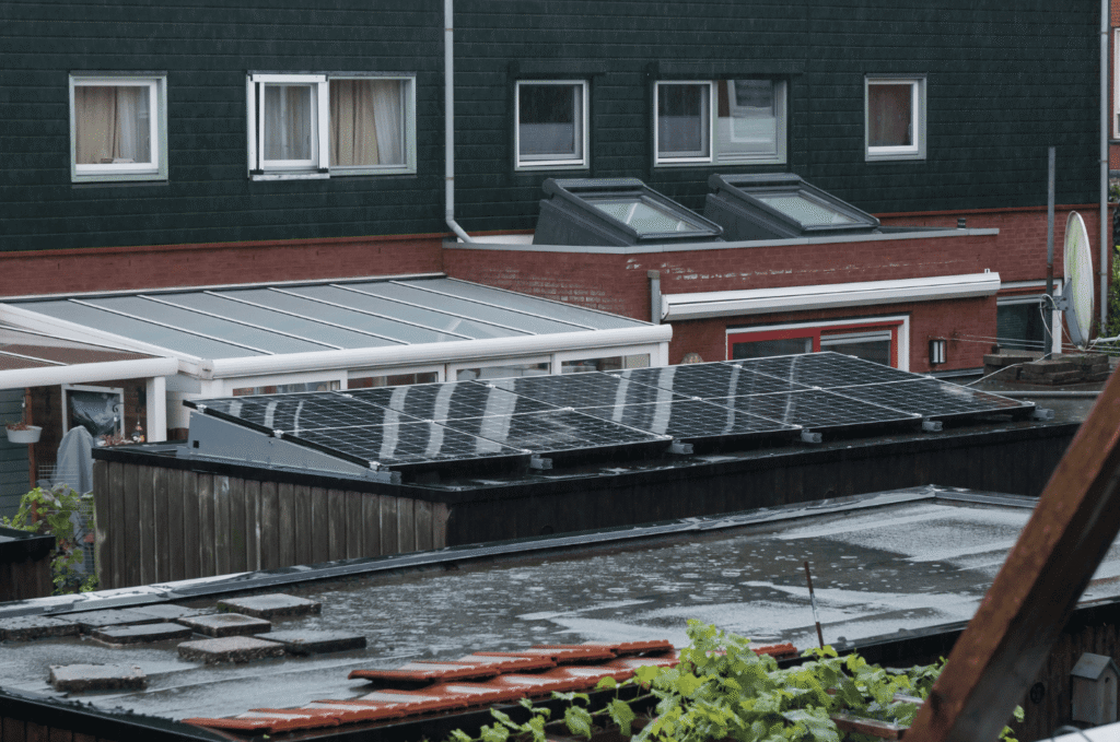 Commercial flat roof with solar panels and visible ponding water, showing drainage issues that can lead to hidden roof leaks.