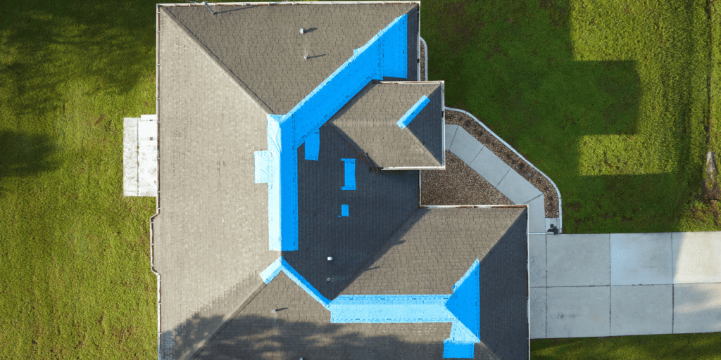 Aerial view of shingle roof with blue tarp protection showing roof leak causes near valleys, roof edges, and gutter lines