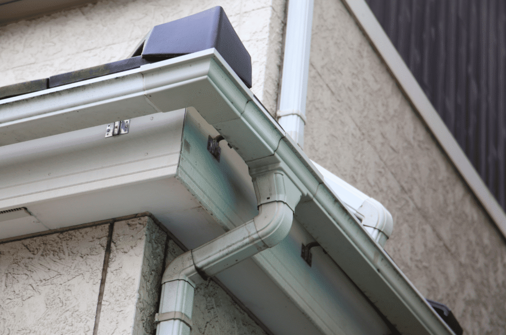 White gutter and roof edge detail showing drip edge flashing area that directs rainwater away from fascia boards in Boston