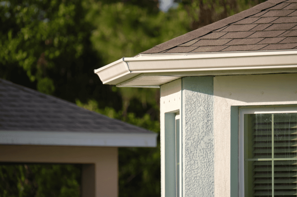 Roof edge with gutter, fascia, and shingles where drip edge flashing should be checked for early moisture signs in Boston