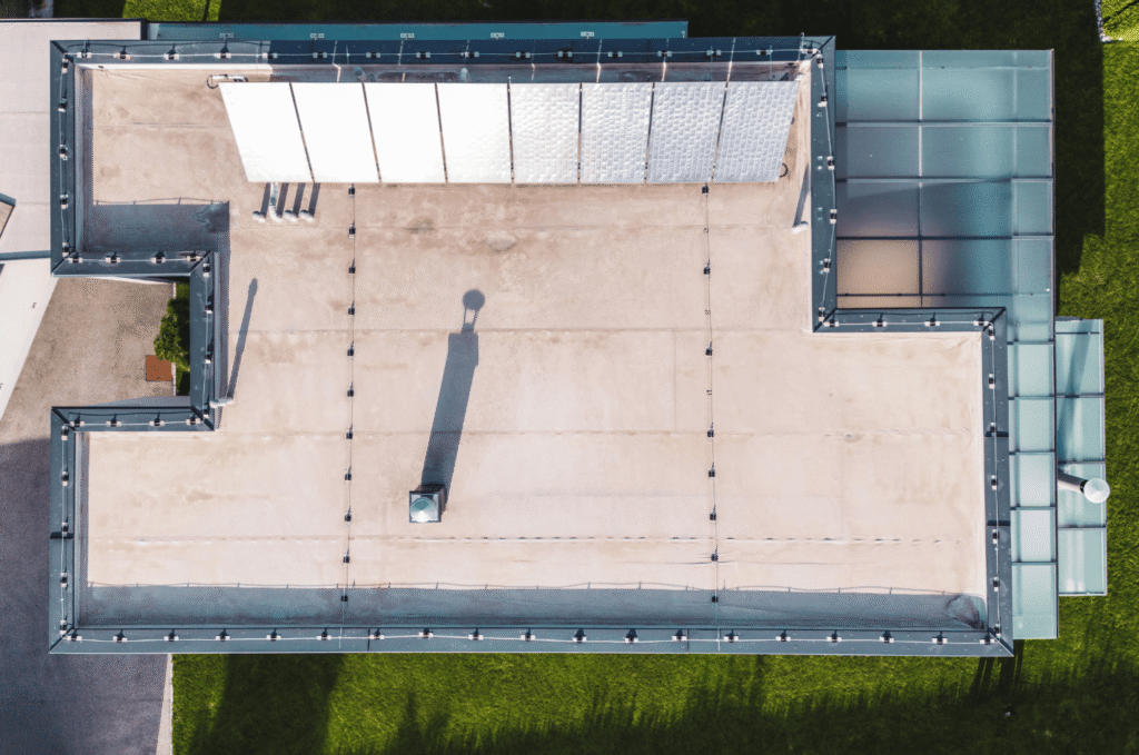 Top-down view of a flat roof with seams and edge drainage, showing key areas to inspect before flat roof drainage repair.